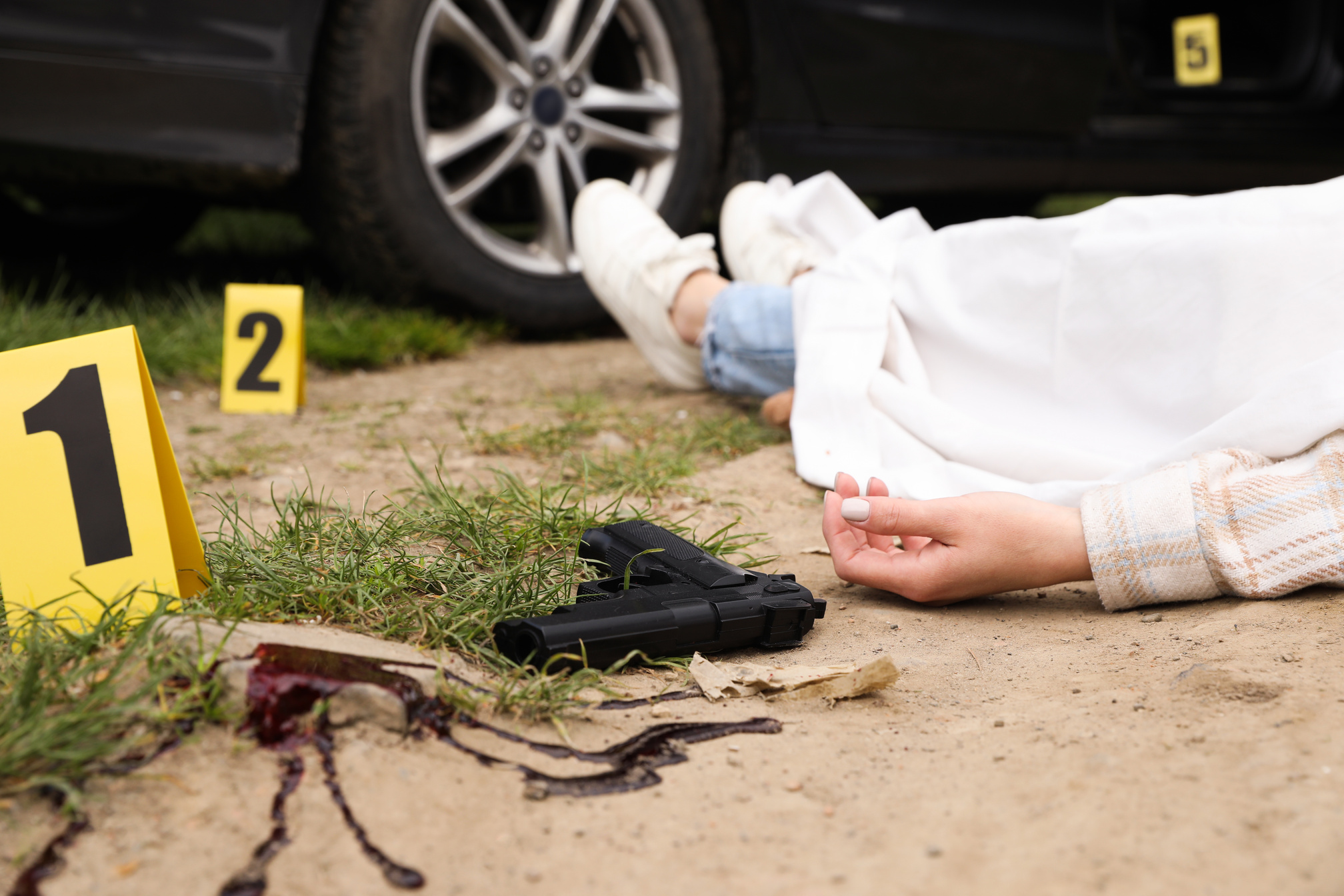 Crime Scene Markers, Dead Woman's Body and Gun Outdoors, Closeup